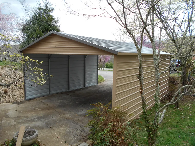Tan and gray boxed-eave carport with enclosed sides next to a house