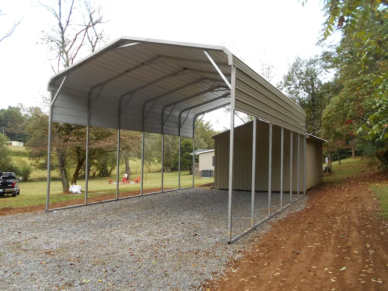 Long white regular-roof carport with open sides on gravel